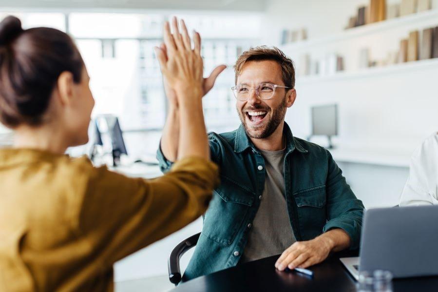 A team member celebrating success by high-fiving their colleague